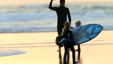 Surfer at the beach with his two daughters. Vídeo Stock 88406378