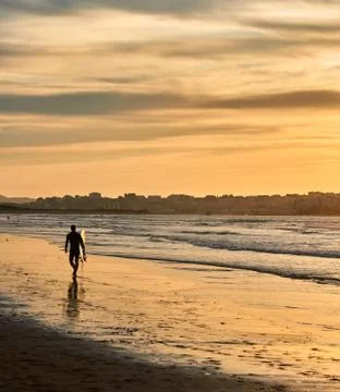 A surfer on the beach Stock Photos