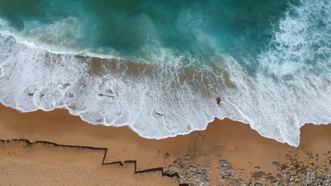 Surfer on the beach top view. Drone shot on a beach in a summer day. Stock Footage 94472475