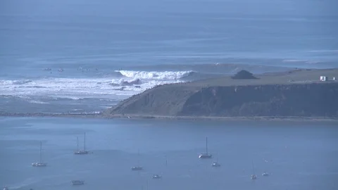 A surfer on a big wave at Mavericks from far away Stock Footage 98365257