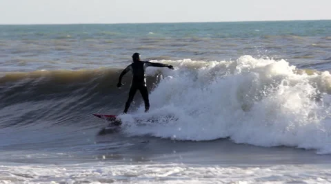 Surfer in a Black Wetsuit Surf on the Wave Stock Footage 63564809