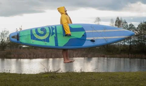 Surfer with a Board in cloudy weather, dynamic photography, Stock Photos