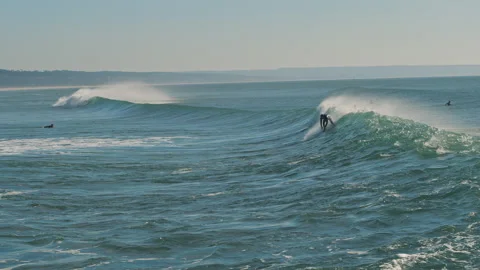 Surfer catching blue wave in the Atlantic Ocean on a beautiful sunny day. Stock Footage 130627775