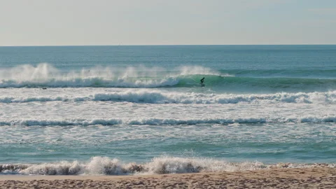 Surfer catching blue waves of the Atlantic Ocean on a beautiful sunny day Stock Footage 130626093
