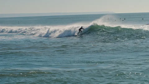 Surfer catching blue waves of the Atlantic Ocean on a beautiful sunny day Stock Footage 130626604