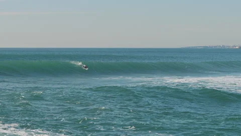 Surfer catching blue waves of the Atlantic Ocean on a beautiful sunny day Stock Footage 130627349