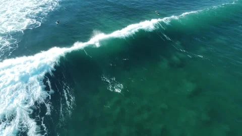 Surfer catching a long wave breaking among other surfers Stock Footage 330884262