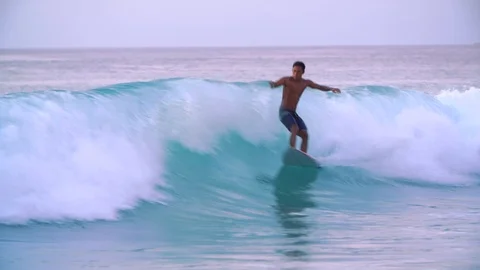 Surfer catching tha wave at sunset, Bali, Indonesia, 4k Stock Footage 121946088