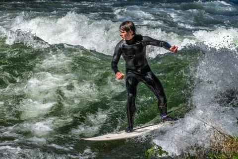Surfer in the city river called Eisbach at Munich, Germany Stock Photos