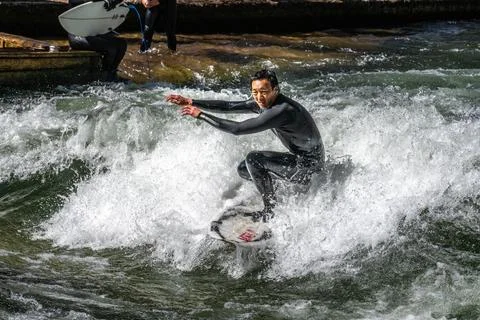 Surfer in the city river called Eisbach at Munich, Germany Stock Photos