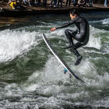 Surfer in the city river called Eisbach at Munich, Germany Stock Photos