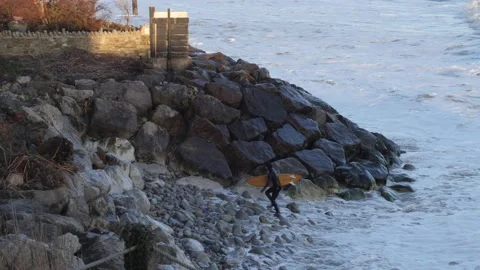 Surfer comes ashore over rocks 2 Stock Footage 238022388