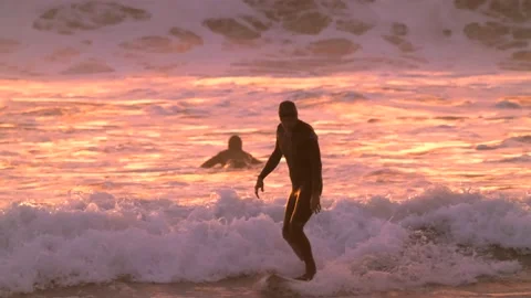 Surfer cruises back towards coast slow motion sunset Stock Footage 146876152