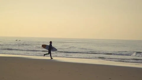Surfer at dawn runs into the sea Stock Footage 248962461