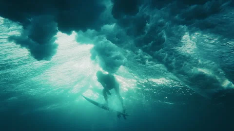 Surfer dives under the ocean wave with surfing board and passes it. Underwater Stock Footage 325057701