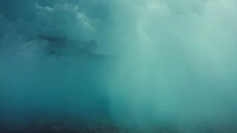 Surfer does the trick named as Duck dive to pass the wave in the murky water Stock Footage 166965273