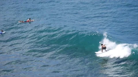 Surfer doing a few turns on a wave throwing nice sprays Stock Footage 131336279