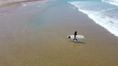 A surfer entering the beach Stock Footage 245761090