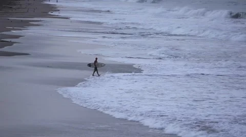 Surfer entering the ocean at dawn Stock Footage 46028956