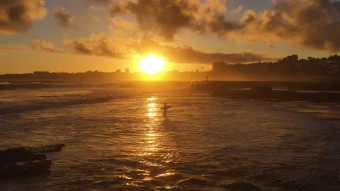 Surfer entering the water during dramatic sunset, part 1 Stock Footage 150239220