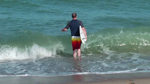 Surfer enters the water Stock Footage 24466431
