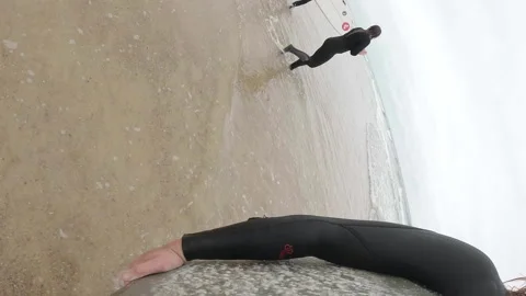 Surfer exiting water board under arm GoPro Stock Footage 342937579