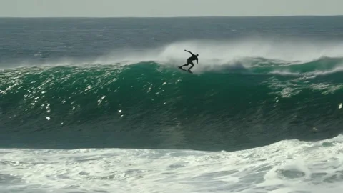 A surfer falls on top of a giant wave. Extreme surfing Nazare Stock Footage 232928492