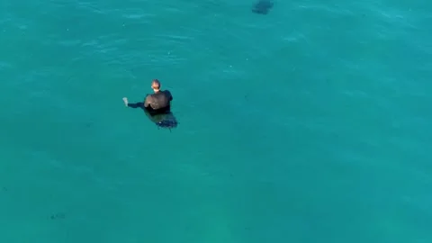 Surfer Floating On Board In The Calm Ocean Water - Drone Shot Stock Footage 267688470