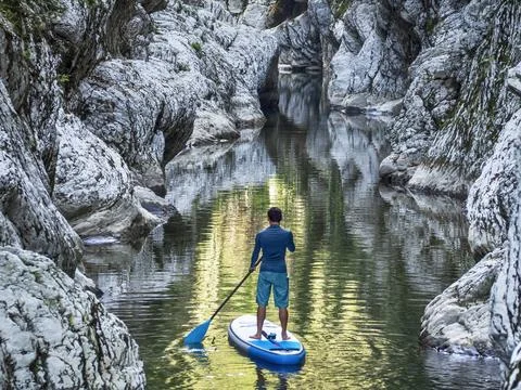 Surfer floating on stand up paddle board Фото