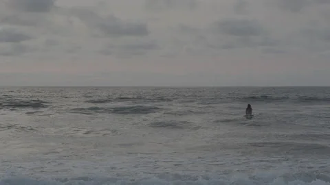 Surfer floating on surfboard in ocean Video stock 140360539