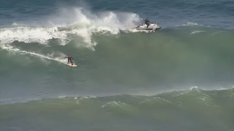 Surfer gets towed into big wave by jet ski Stock Footage 39962931