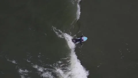 Surfer glides on a board in the cold sea, top view Stock Footage 163205185