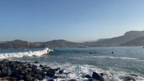 Surfer Goes By Rocks HD Stock Footage 175345670