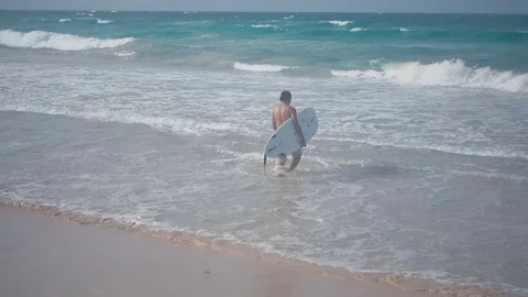 The surfer goes into the water Stock Footage 73828886