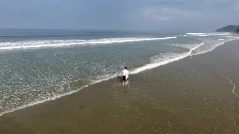 Surfer going into the water Stock Footage 145147453