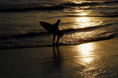 A surfer guy at the sunset Stock Photos