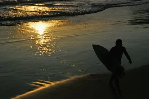 A surfer guy at the sunset Stock Photos