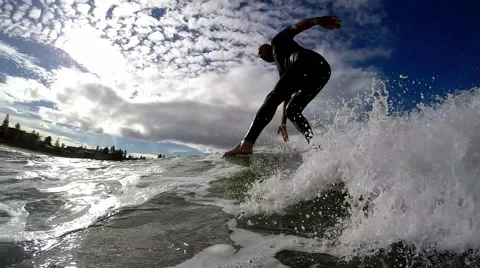 Surfer 'hangs five' on the nose of his long board. Slow motion 120fps Video stock 64357550