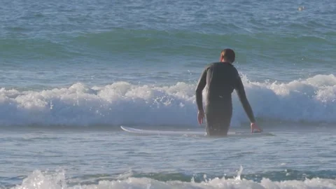 Surfer with his surfboard walking towards ocean, going to ride the wave Vídeo Stock 138025372