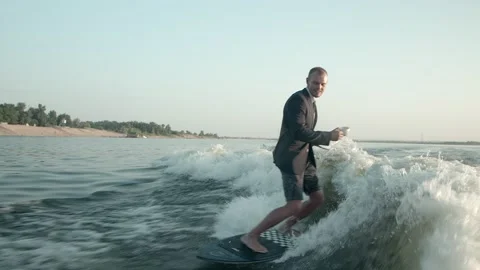 A surfer jumping on a wakeboard in a suit with a cup Video stock 160401796