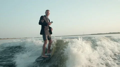 A surfer jumping on a wakeboard in a suit. Video stock 160404894