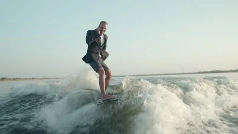 A surfer jumping on a wakeboard in a suit. Stock Footage 160405064