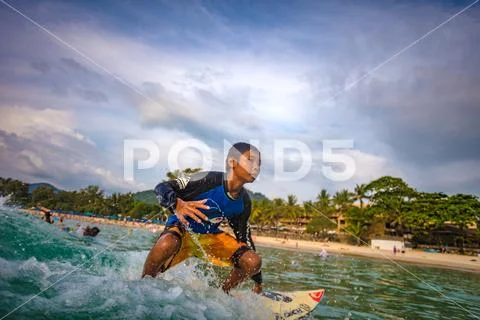 Surfer kid a little boy riding a wave Stock Photos