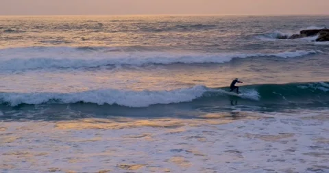 Surfer learning surf small wave black man slow motion surfing sunset golden hour Stock Footage 273503612