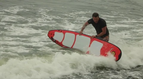 Surfer leaving Ocean, Walking on Rocks Video stock 48474618