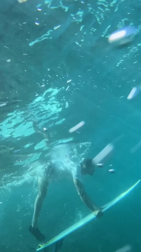 Surfer making duck dive in the ocean. vertical video Stock Footage 295113279