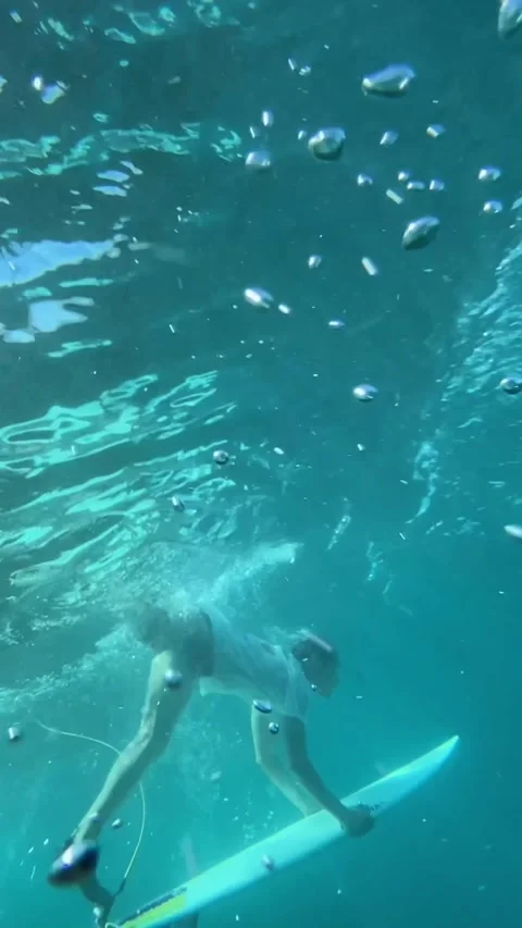 Surfer making duck dive in the ocean. vertical video Stock Footage 295113319