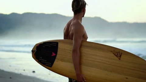 Surfer man with surfboard on beach. Millennial male. Beautiful young guy  Stock Footage 108565281