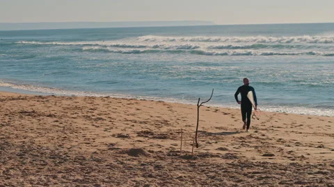 Surfer man with surfing board running on the beach after surfing in the ocean Stock Footage 130629231