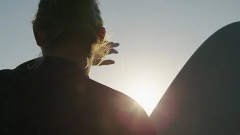 Surfer man walking to the beach at sunset preparing for surfing training and Stock-Footage 296014765